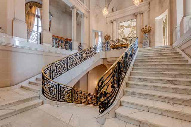 Elegant staircase with wrought-iron railings in The Perry Belmont House for upscale events.