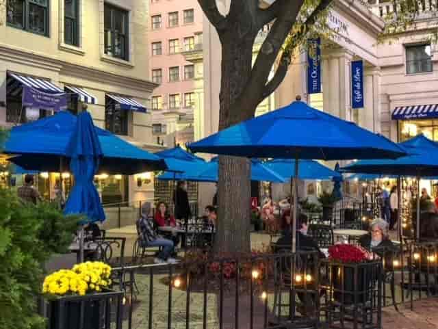 Outdoor dining at Occidental Grill with blue umbrellas, ideal for networking events.
