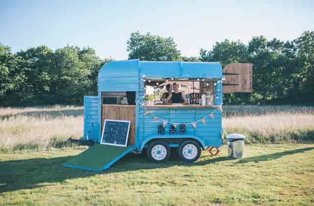 Charming blue mobile bar setup for outdoor weddings and events at Church Farm Estate.