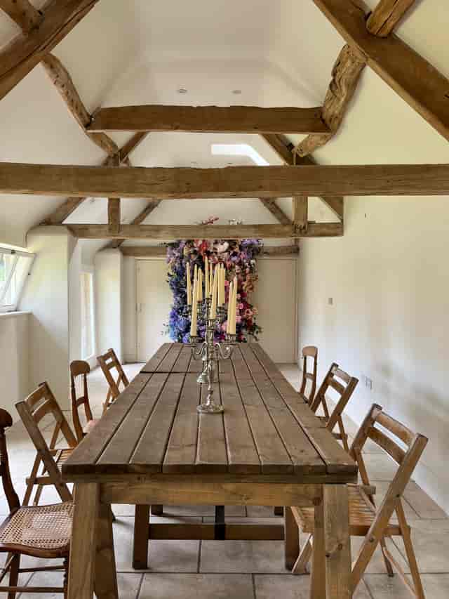 Rustic wooden table with candles in a charming meeting space for workshops and gatherings.