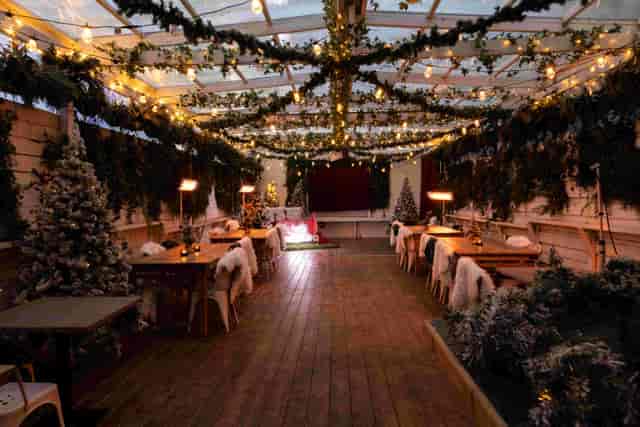 The Secret Garden at The Exhibit Balham, a cozy winter pop-up with festive lighting and greenery.