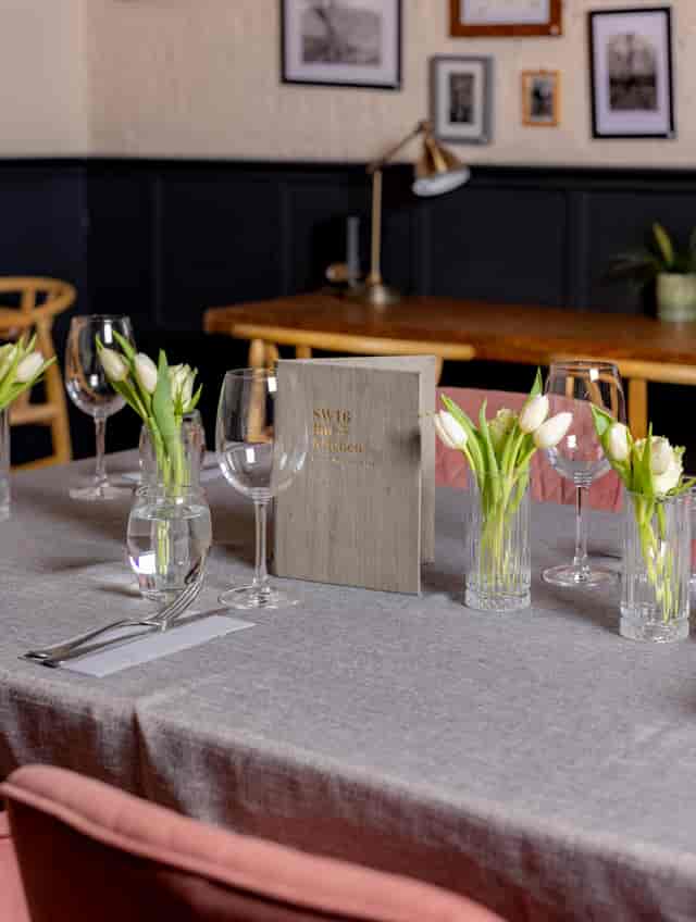 Elegant meeting table with glassware and tulips at Snug SW16 Bar and Kitchen.