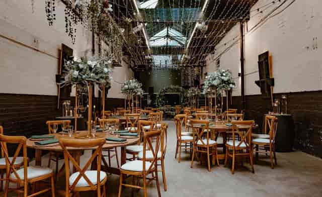 Elegant event space with round tables, floral centerpieces for weddings and gatherings.