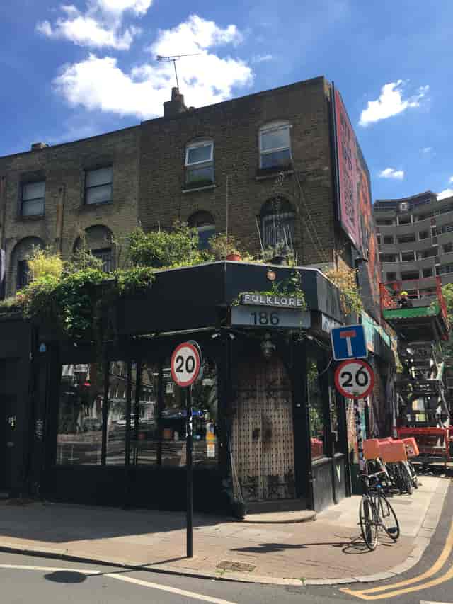 Charming Folklore venue exterior with greenery, ideal for networking events and workshops.