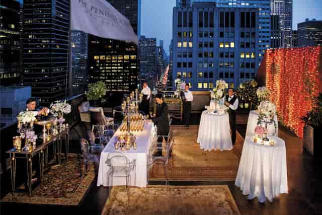 Sophisticated rooftop event at Gramercy, featuring floral centerpieces and skyline views.