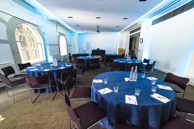 "Bright meeting space with round tables for corporate workshops at Friends House."