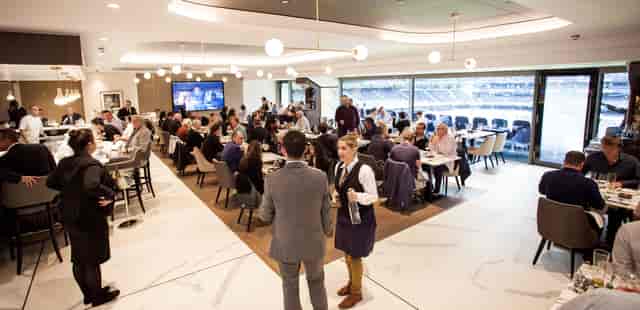 Corporate event at The H Club, Tottenham Hotspur Stadium, featuring elegant decor and networking.