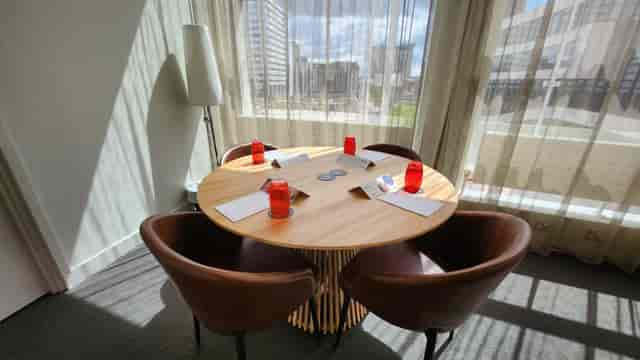 Bright meeting space with round table, ideal for brainstorming and small group discussions.