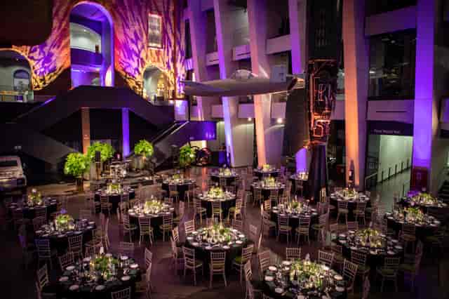 Atrium at IWM London set for an elegant gala with fine dining and warm ambiance.