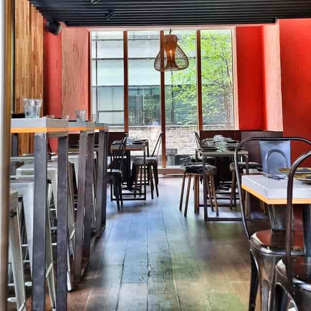 Modern dining venue with wooden floors, ideal for intimate gatherings and events.