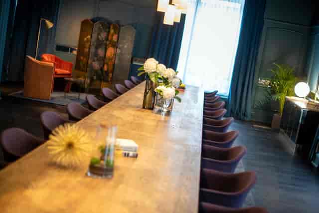 Stylish meeting space with wooden table in Renaissance Brussels Hotel, ideal for events.