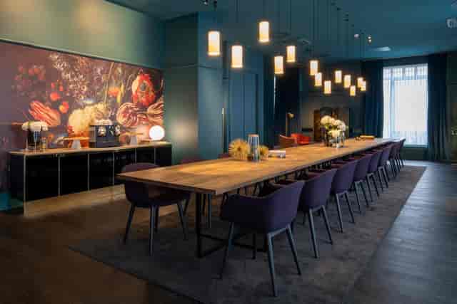Sophisticated meeting space with wooden table and purple chairs for executive events.