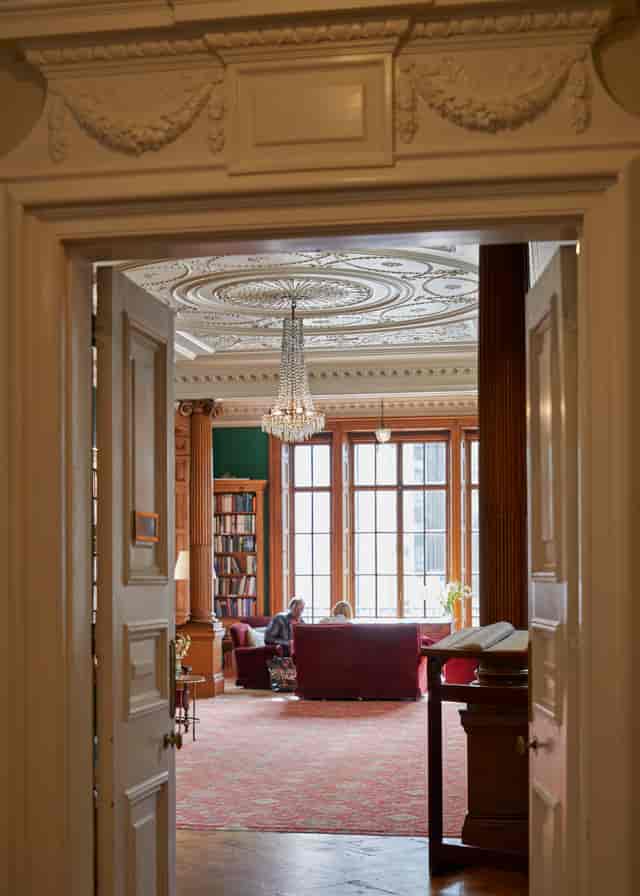 Elegant library meeting space with chandelier, ideal for intimate gatherings and events.