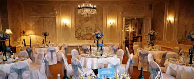 Elegant event space with round tables and floral centerpieces for weddings and corporate events.