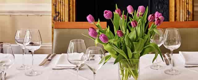 Elegant dining room with purple tulip centerpiece for upscale events and gatherings.