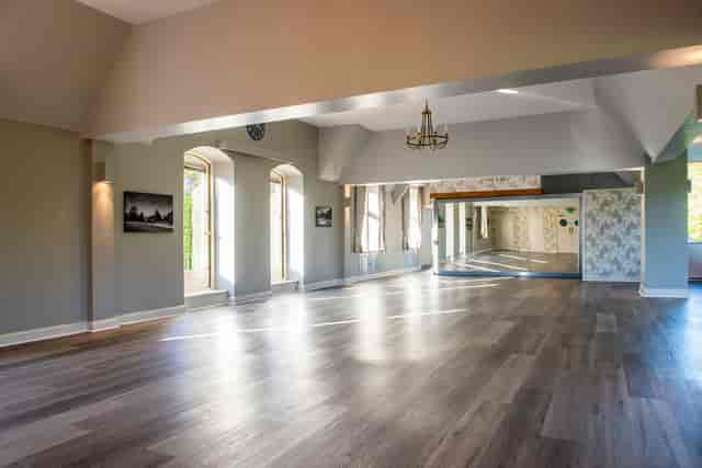 Spacious event venue with polished wooden floor, ideal for corporate and social gatherings.