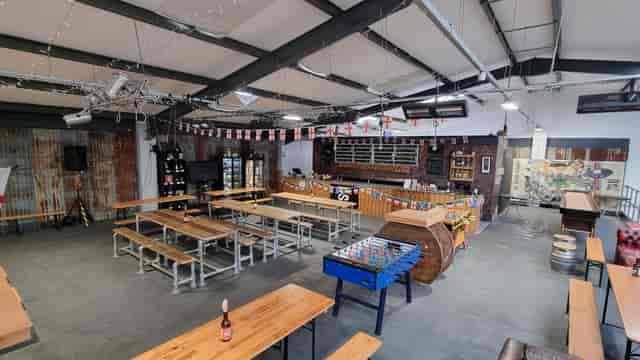 The Mezzanine at dISruption Brewery: industrial event space with communal tables for gatherings.