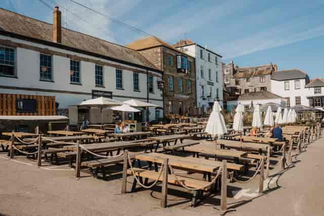 Spacious outdoor venue with wooden tables for casual gatherings and festivals.