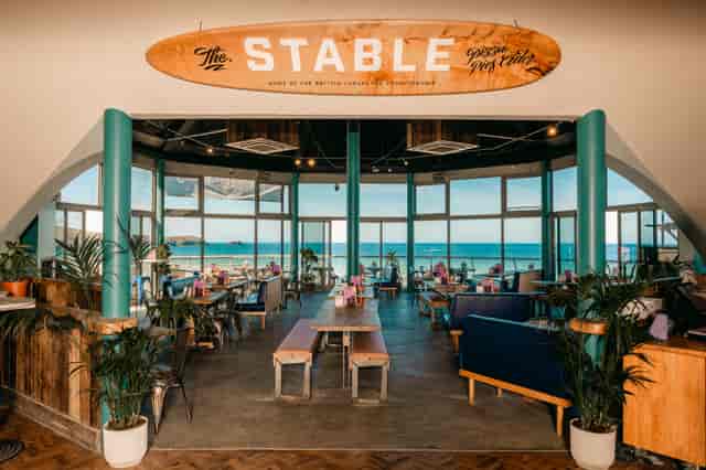 Vibrant event space with surfboard decor, ideal for meetings and gatherings by the beach.