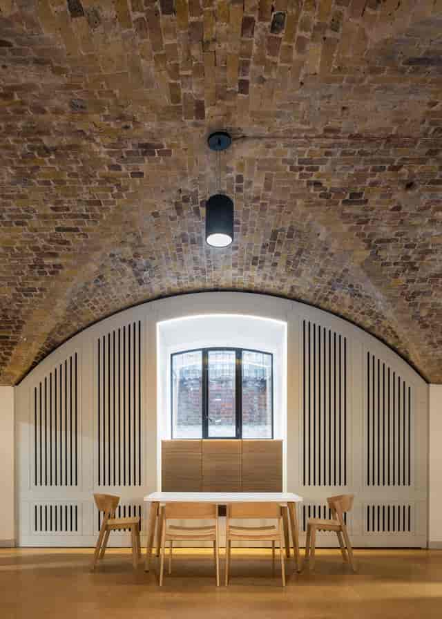 Stylish event space with arched brick ceiling, perfect for meetings and social gatherings.