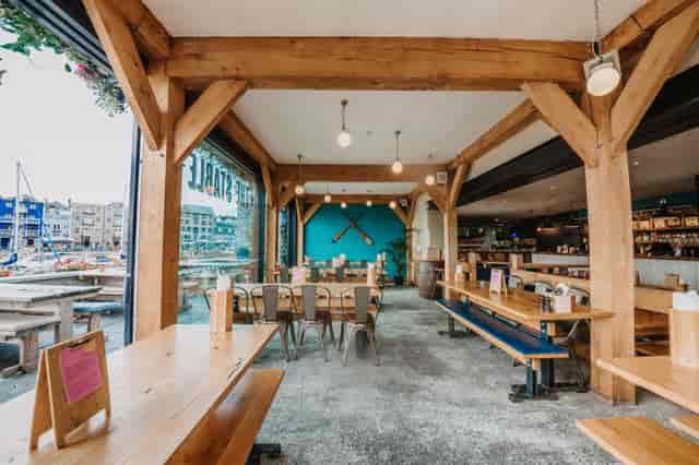 Spacious modern venue with rustic beams, perfect for casual meetings and social events.