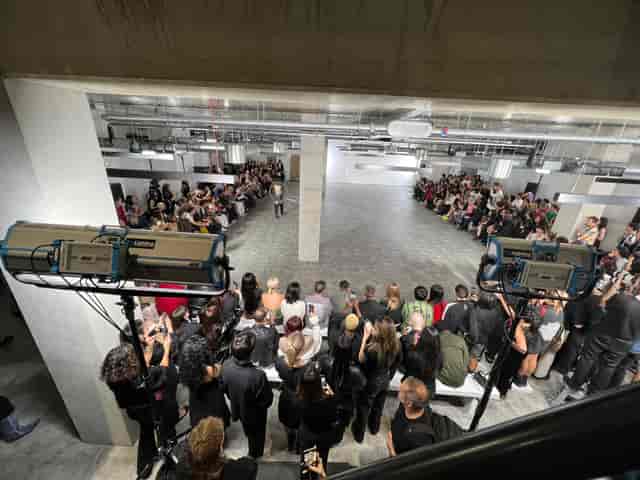 Industrial-chic warehouse runway at The Block; minimalist fashion show event space.