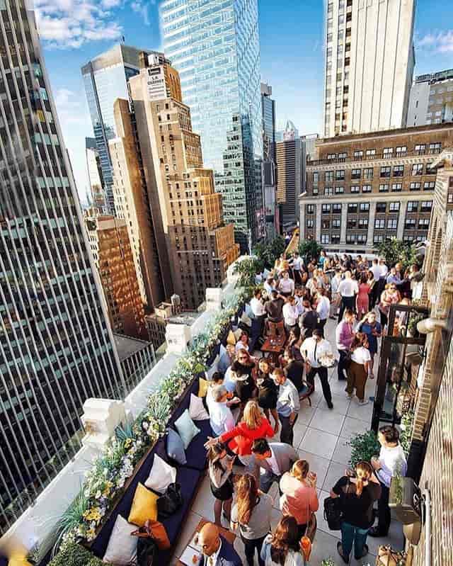Vibrant rooftop event at Dear Irving with skyline, ideal for corporate networking and celebrations.