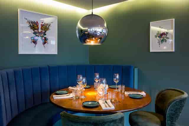 Private dining room with round wooden table, ideal for intimate meetings and events.