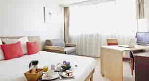 Business hotel room in Novotel Paris with cozy seating and workspace for meetings.