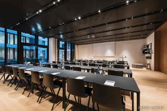 Modern meeting room in Munich with long tables, ideal for corporate events and workshops.