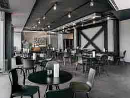 Modern event space in Munich with sleek black furniture, ideal for meetings and workshops.