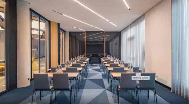 Modern meeting studio in Andaz Munich with natural light, perfect for corporate events.