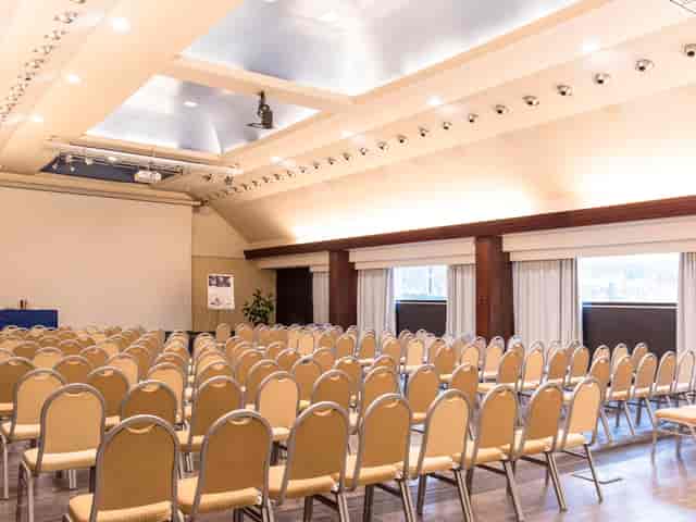 Spacious Mercure Roma West meeting room set for a conference with beige chairs.