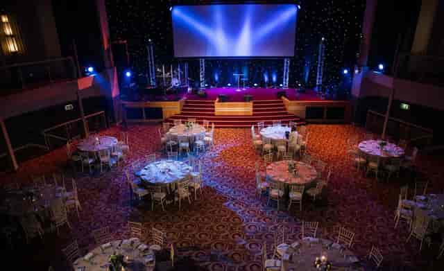 Elegant Lighthouse Venue gala setup with round tables and stage for corporate events.
