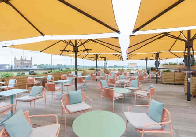 Curzon Kingston outdoor event space with colorful seating and yellow umbrellas for summer gatherings.
