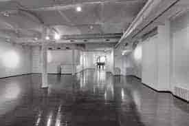Spacious event venue with polished floors, ideal for exhibitions and networking.