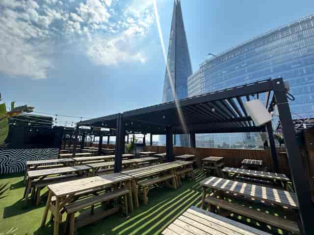 London Bridge Rooftop venue with wooden tables, perfect for summer events and networking.