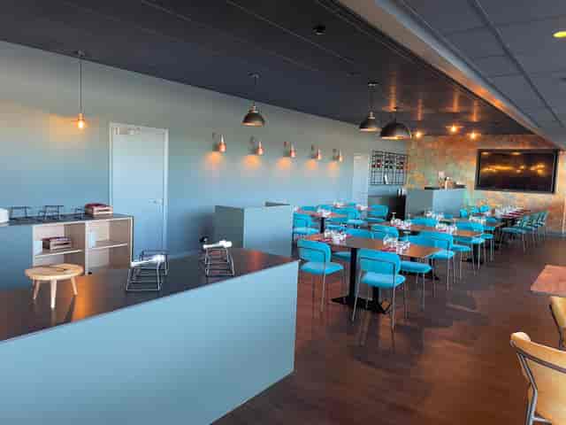Modern event space at The Twickenham Stoop with turquoise chairs for networking events.