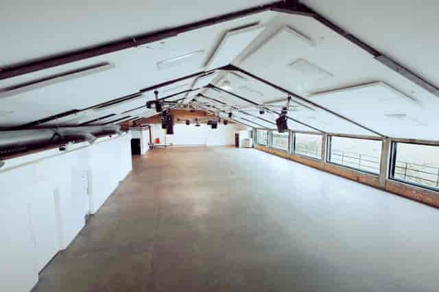 Spacious event venue with high ceiling, ideal for meetings and workshops at OVAL STUDIOS.