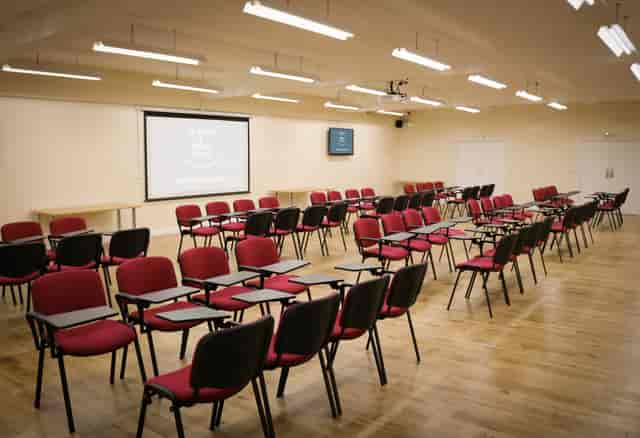 Classroom-style meeting space with red chairs at Manor & Ashbury Resorts for workshops.