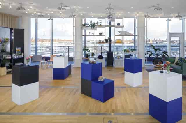 Modern event space in Zoku with geometric pedestals, ideal for showcases and networking.