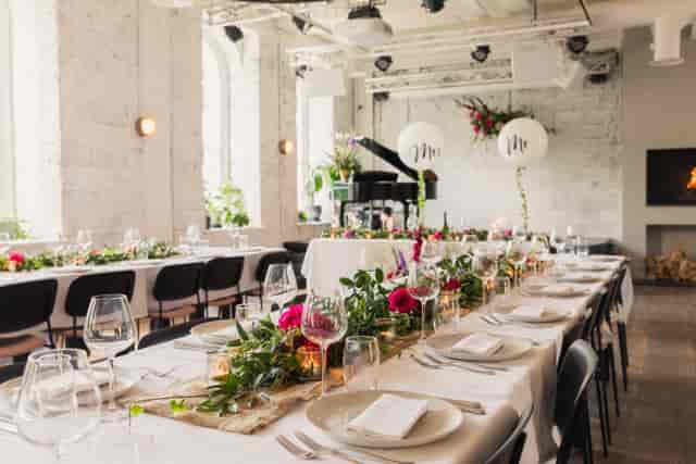 Elegant event space at The Hall in Kindred with floral centerpieces and soft lighting.