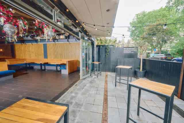 Versatile outdoor event space with modern high-tops, ideal for gatherings and networking.