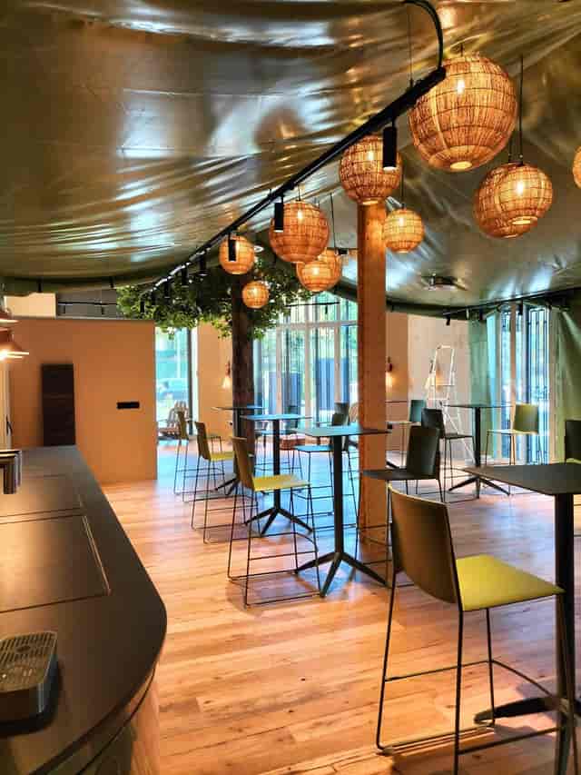 Versatile event space in Comet Retiro with warm lighting, ideal for networking and workshops.