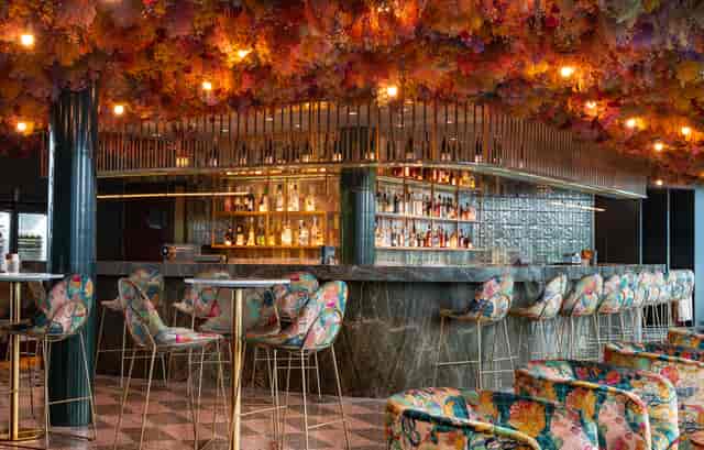 Vibrant bar area with floral ceiling, ideal for networking events and cocktail receptions.