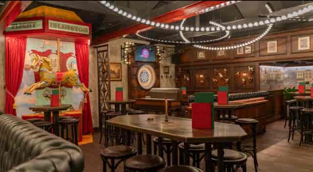 Vibrant event space at Flight Club Islington with playful carousel backdrop for gatherings.