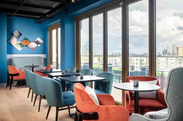 Modern meeting space with blue walls, ideal for networking and brainstorming events.
