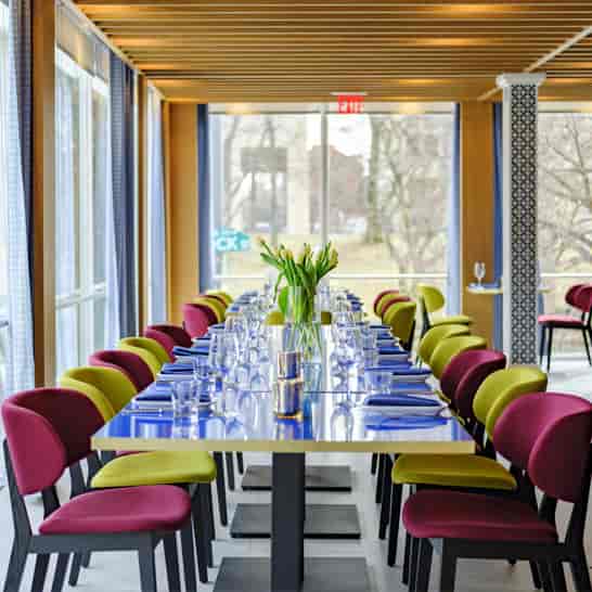 Private dining room in Positano Coast with vibrant chairs for corporate events.