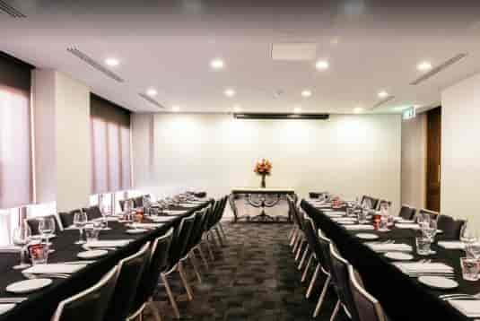 Elegant meeting room with black tablecloths, ideal for corporate events and conferences.