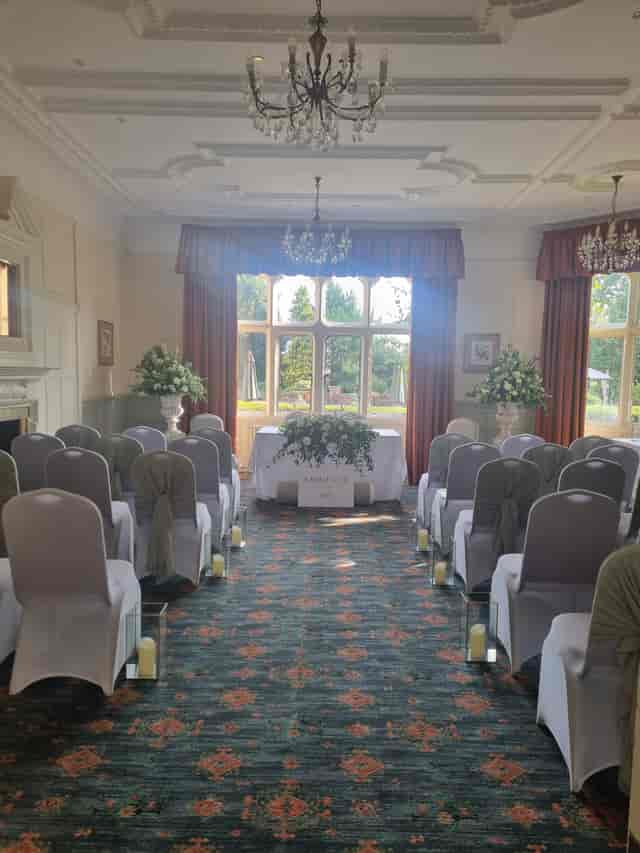Elegant wedding ceremony setup at Warren House Hotel with floral arrangements and soft green sashes.